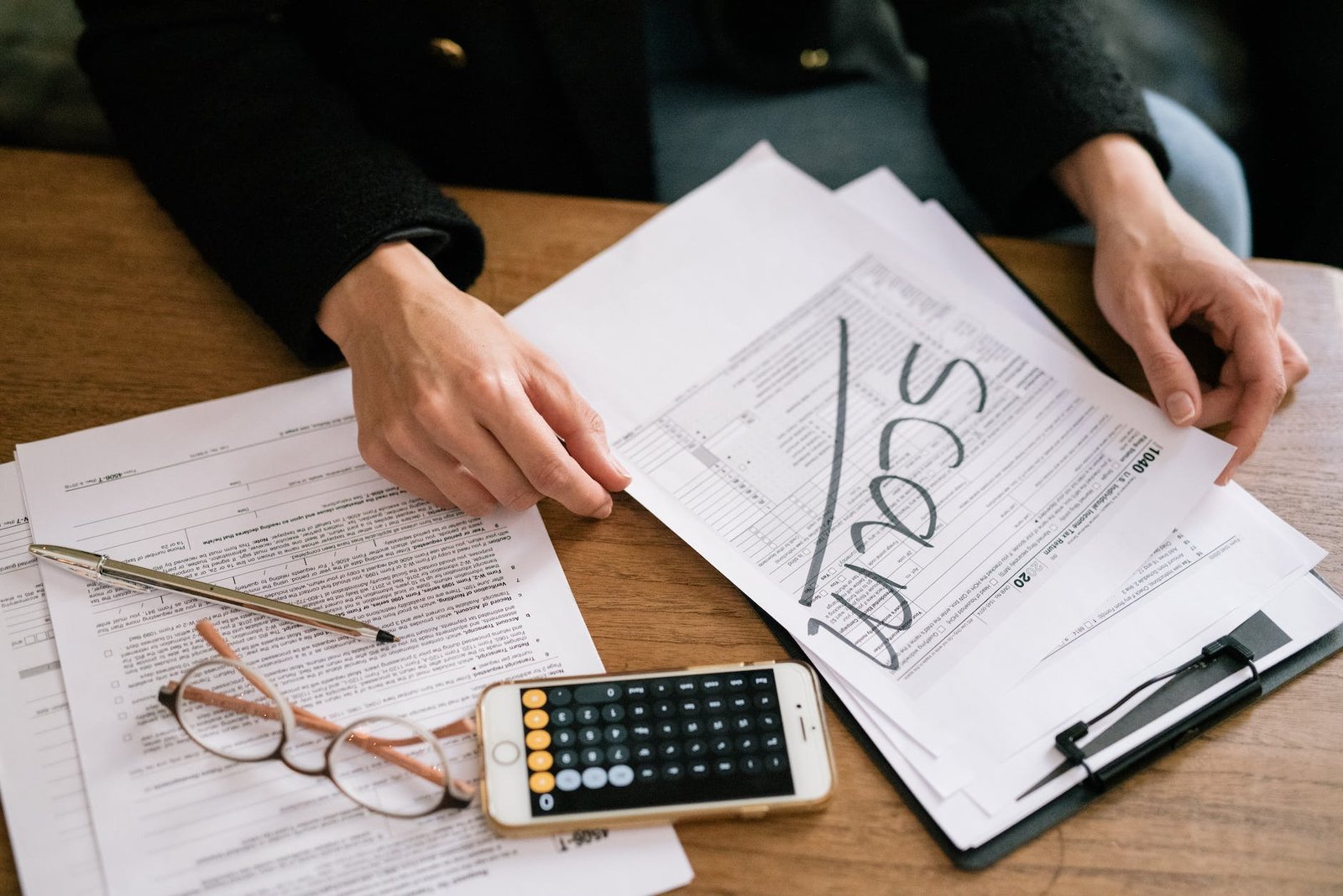 Fraud Detection - Technology - a person holding a tax form a person holding a tax form