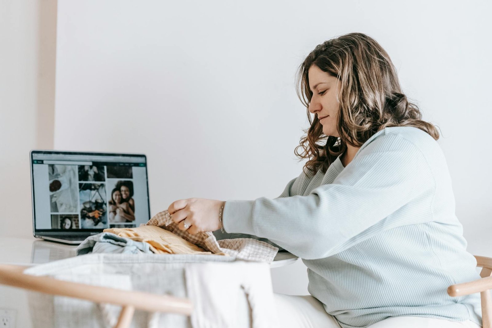 What To Pack In Hospital For Baby - Health - woman folding baby clothes near laptop woman folding baby clothes near laptop