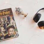 harry potter book and black headphones with trinket