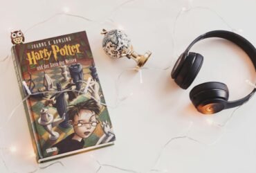 harry potter book and black headphones with trinket
